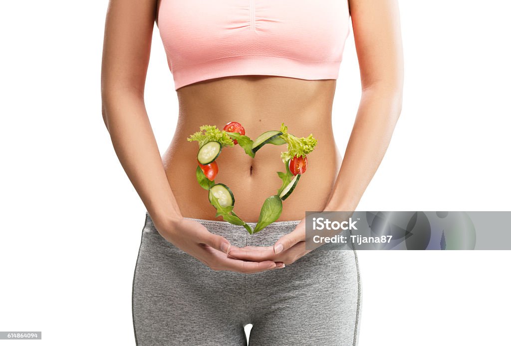 Fit, junge Frau hält ein Herz aus Gemüse - Lizenzfrei Bauch Stock-Foto