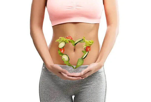 Photo of Fit, young woman holding a heart made out of vegetables