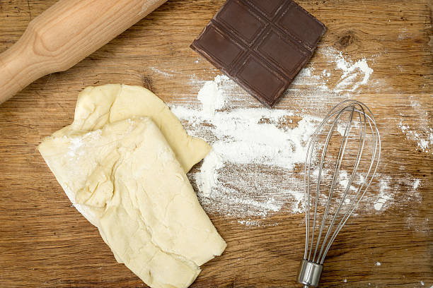 Closeup of rolling pin, chocolate, flour and dough