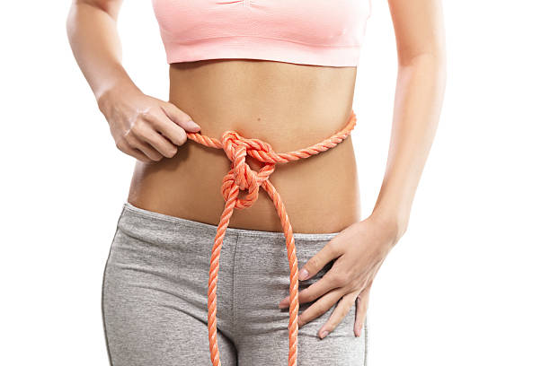 Woman's abdomen tied with a rope, conceptual Woman's abdomen tied with a rope, conceptual bound woman stock pictures, royalty-free photos & images