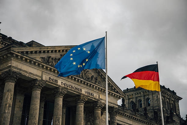 Reichstag and flags The Reichstag building in Berlin, Germany, with a gernan and a european union flag. bundestag stock pictures, royalty-free photos & images