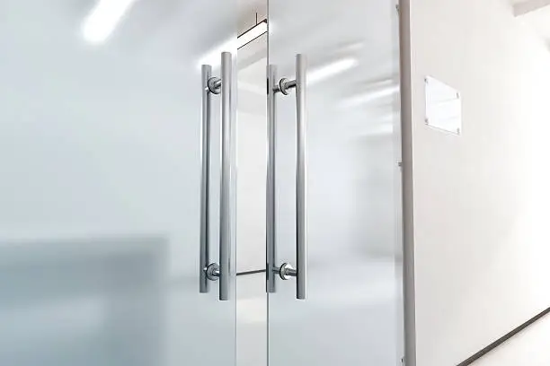 Photo of Blank glass door with metal handles mock up,