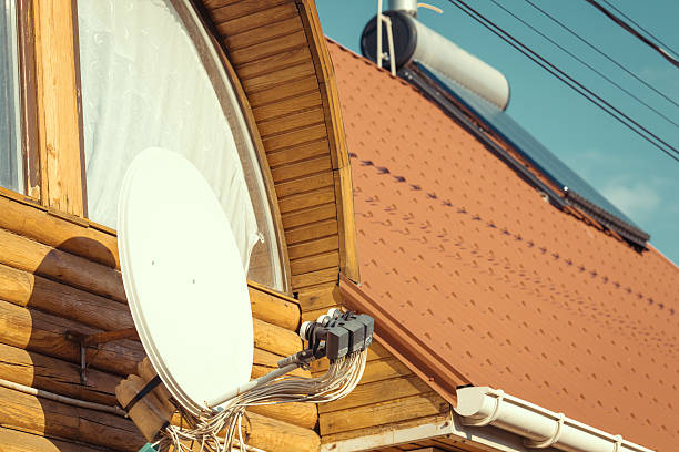 istock Side view of white satellite dish with blue sky 614869488