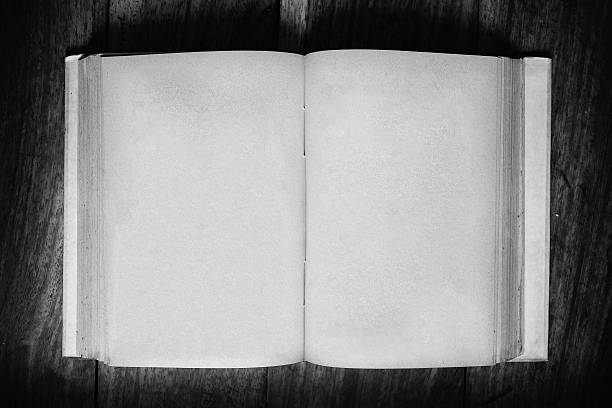 Opened old grunge empty page paper book on wooden table - vintage, black and white effect