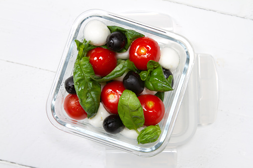 Kids lunch box: cherry tomatoes, olives, mozzarella, basil and olive oil