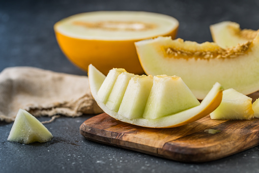 sliced ripe melon on rustic wooden background