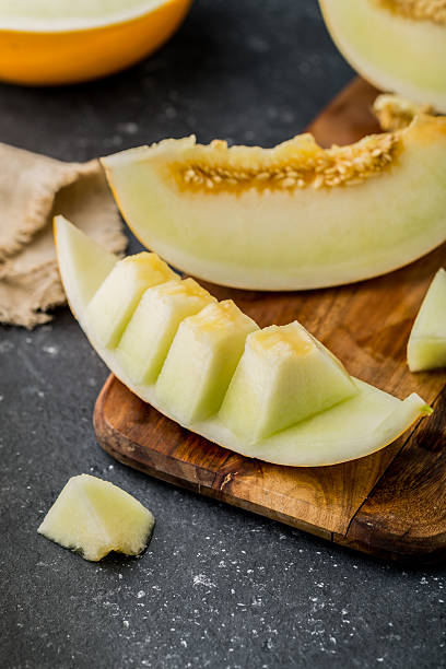 istock sliced ripe melon on rustic wooden background 614872596
