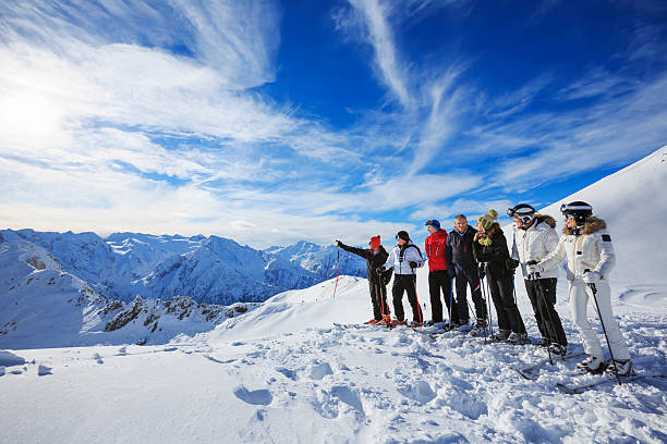 группа skiiers наслаждается солнечным днем на вершине снежной горы - ski skiing european alps resting стоковые фото и изображения