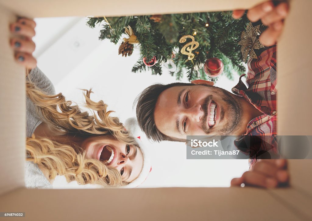Junges Paar öffnet ein Weihnachtsgeschenk - Lizenzfrei Weihnachten Stock-Foto