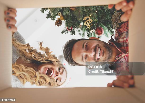 Junges Paar Öffnet Ein Weihnachtsgeschenk Stockfoto und mehr Bilder von Weihnachten - Weihnachten, Geschenk, Öffnen