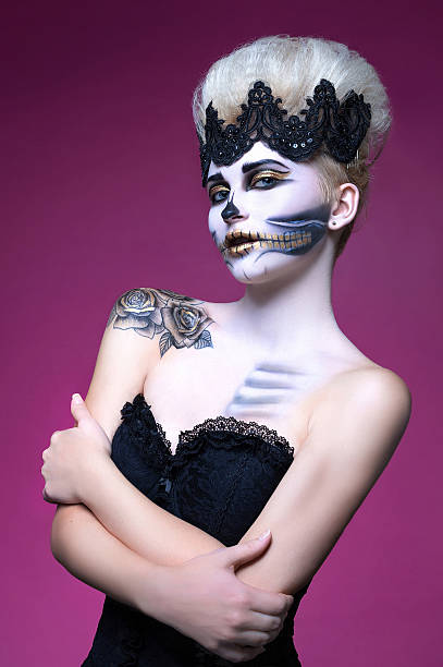 istock beautiful woman with make-up skeleton half 614877276
