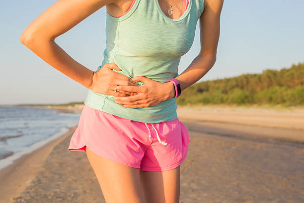 kobieta biegacz o skurcze żołądka - breathing exercise jogging exercising relaxation exercise zdjęcia i obrazy z banku zdjęć
