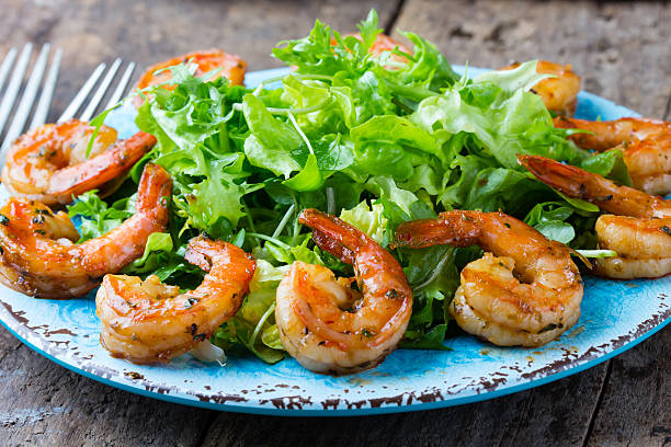 istock Seafood shrimp lettuce salad on blue plate 614878542