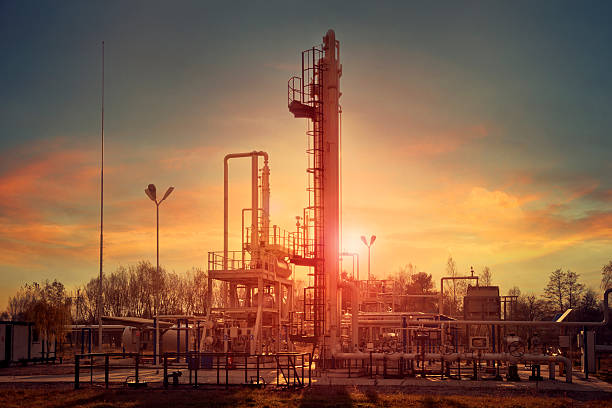 Natural gas compression for dehydration Natural gas compression processing plant for dehydration at sunset with beautiful color sky compressor stock pictures, royalty-free photos & images