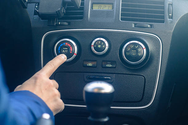istock man is turning on car air conditioning system 614957808