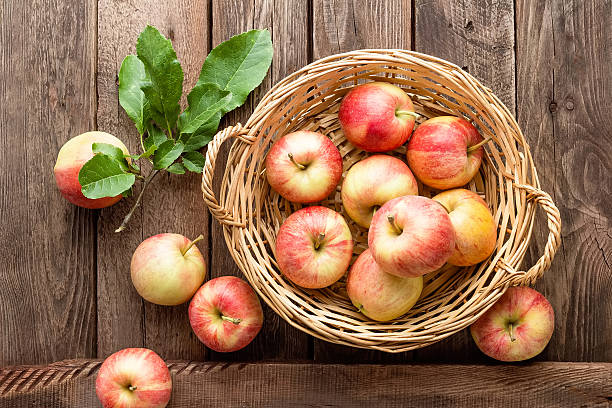 istock fresh apples in wicker basket on wooden table 614958464