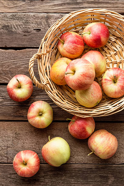 istock fresh apples in wicker basket on wooden table 614958632