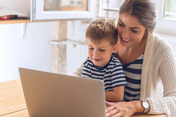 Madre e figlio giocano su un computer - foto stock