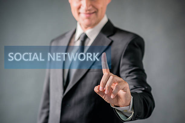 istock Smiling businessman pointing at virtual  social network sign 614959814