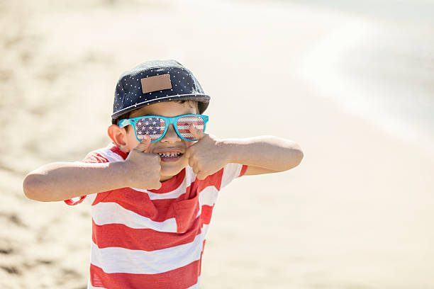 feliz menino patriótico usando óculos de bandeira americana - child flag patriotism thumbs up - fotografias e filmes do acervo