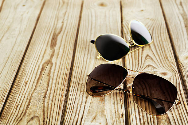 istock two unisex sunglasses close-up on a wooden background 614961524