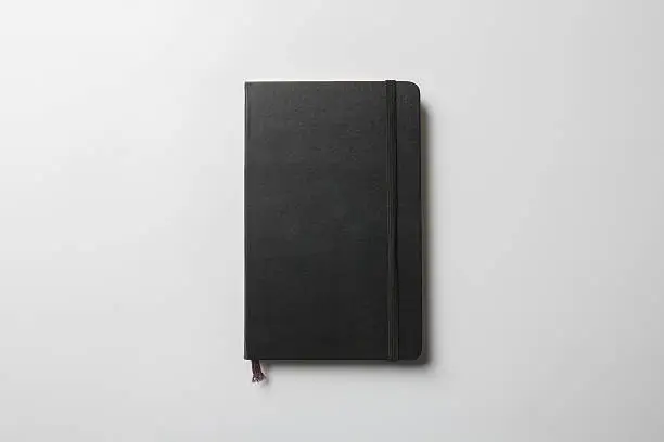 Black Cover Notebook Mock-up with elastic band closure, ready to replace your design.