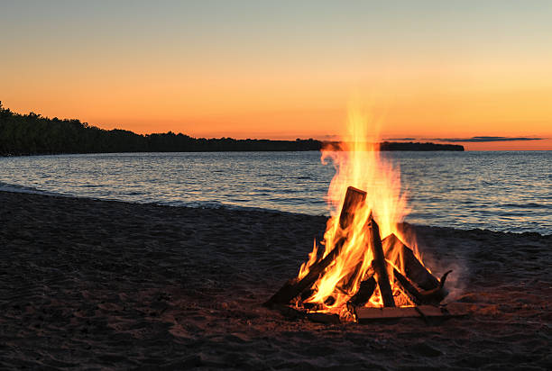 ognisko na plaży z pięknym zachodem słońca - beach sunset sand wood zdjęcia i obrazy z banku zdjęć