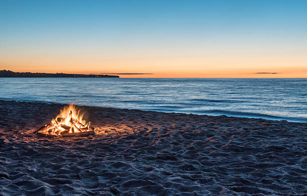 Bonfire at the Beach at Sunset Bonfire on sandy beach at sunset campfire stock pictures, royalty-free photos & images