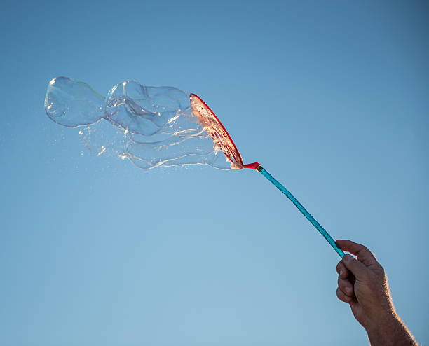 istock Bubble Wand and Soap Bubbles Against Blue Sky 614962906