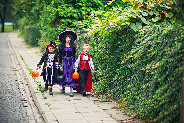 istock Kids with candy buckets walking on Halloween 614964398
