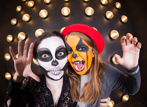 Woman and girl with painted faces. Halloween theme Woman and girl with painted faces. Body art. Halloween theme halloween face paint stock pictures, royalty-free photos & images