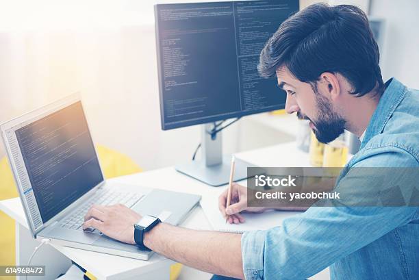 Concentrated Man Coding On A Laptop Stock Photo - Download Image Now - Computer Programmer, Coding, Laptop