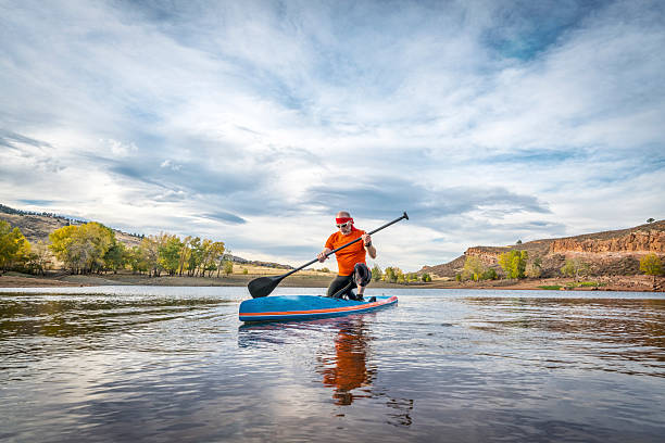 istock stand up paddling on lake 614968690