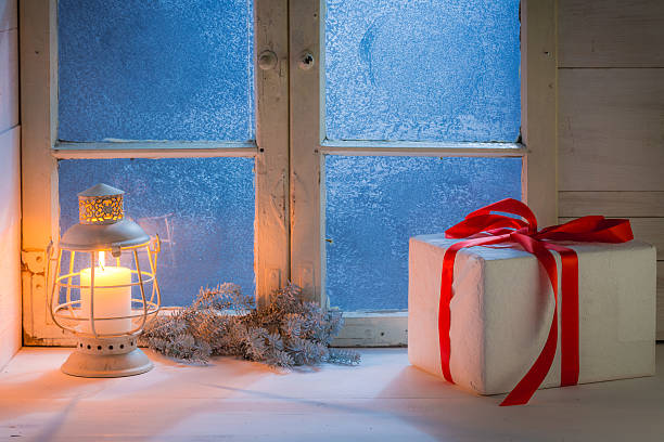 istock Frosted window with burning candle for Christmas at night 614969420