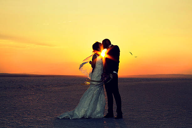 istock Bride and groom kissing on snow 614969910