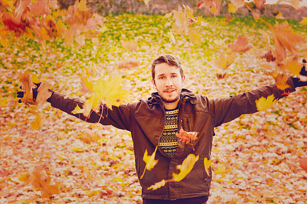 istock Young man is happy about the colorful maple leaves. 614970036