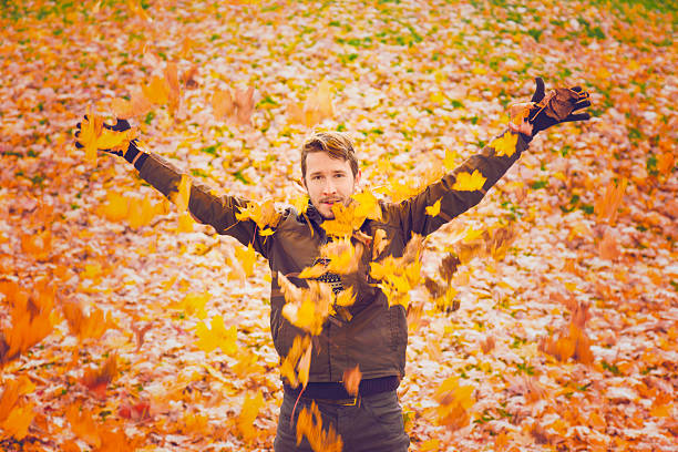 istock Young man is happy about the colorful maple leaves. 614970138