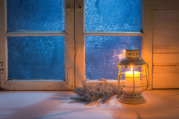 istock Frosted blue window with burning candle for Christmas at night 614970968