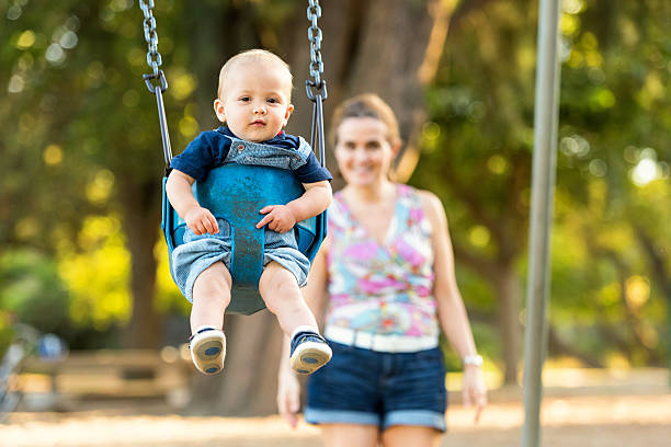 istock Mother and baby having fun in a park 614972504