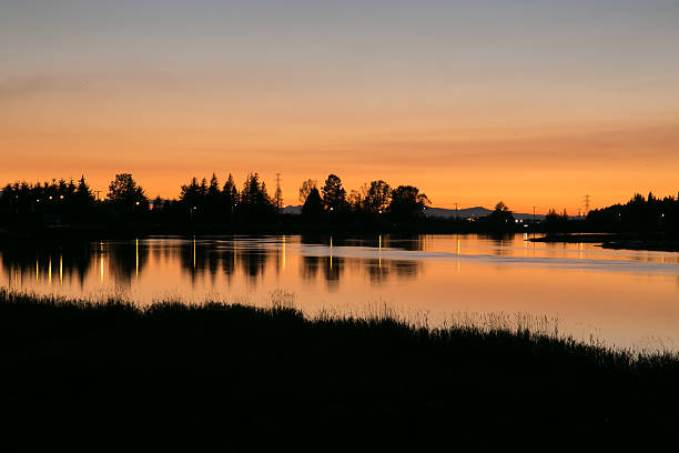 istock silhouette of sunset glow over river 614974856