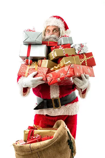 Photo of santa claus holding many presents isolated on white