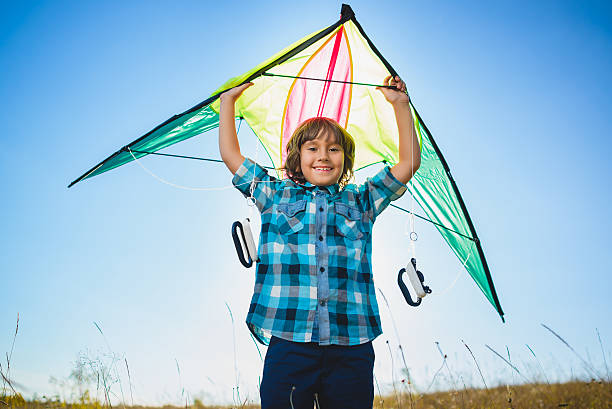 istock Happy and smiling boy playingin with kite outdoor 614977008