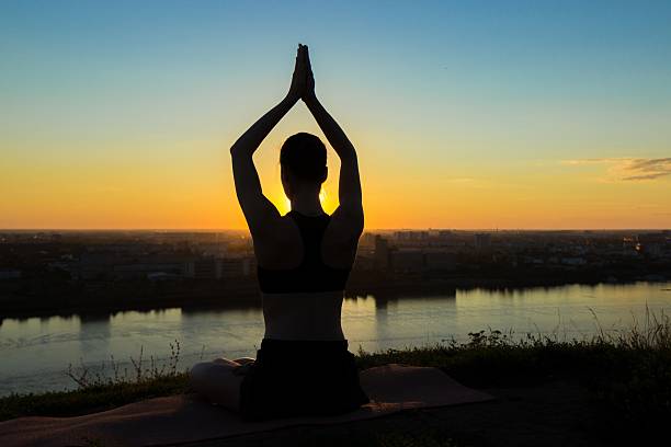 istock Sporty woman practicing yoga at sunset - sun salutation 614977284