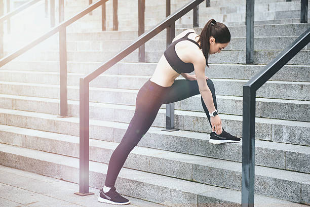 istock Young girl doing exercises on stadium stairs. 614978196