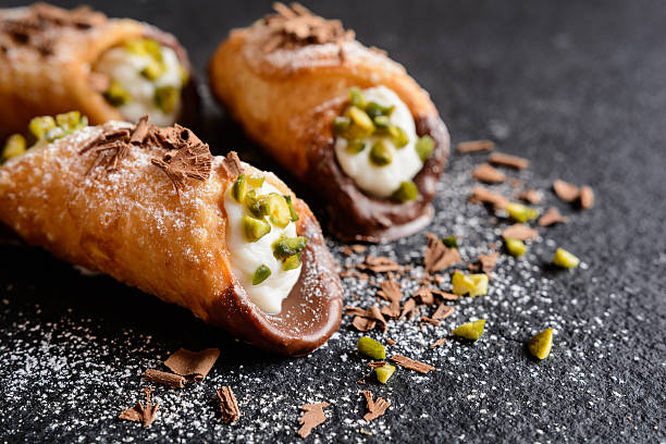 Traditional Sicilian cannoli stuffed with ricotta and pistachios Cannoli Siciliani - traditional dessert stuffed with ricotta cream and pistachios Cannoli stock pictures, royalty-free photos & images