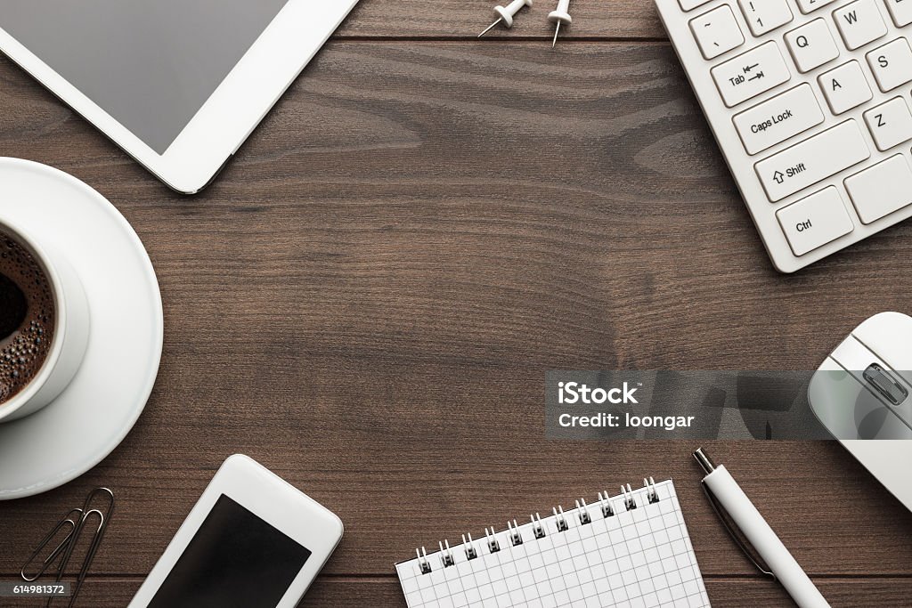 overhead of office table with copy space overhead of office table with notebook, computer keyboard and mouse, tablet pc and smartphone. copy space Wood - Material Stock Photo