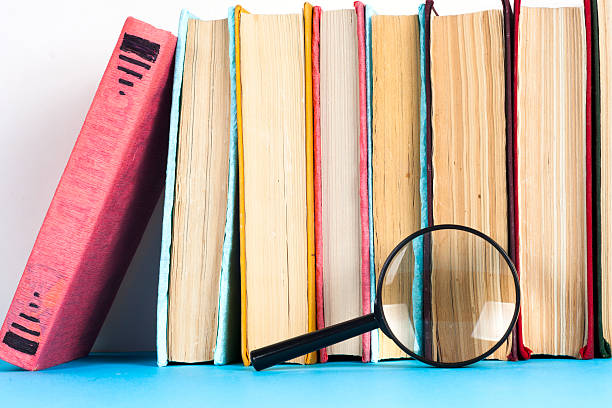 istock Open book, stack of colorful hardback books on light table. 614981660