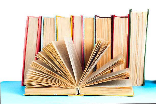 istock Open book, stack of colorful hardback books on light table. 614981970