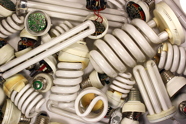 Old burnt fluorescent energy saving lamps. Old burnt fluorescent energy saving lamps. Hazardous and toxic electronic waste energy efficient lightbulb stock pictures, royalty-free photos & images