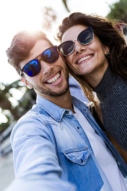 istock Happy young couple using mobile phone in the street. 614985068